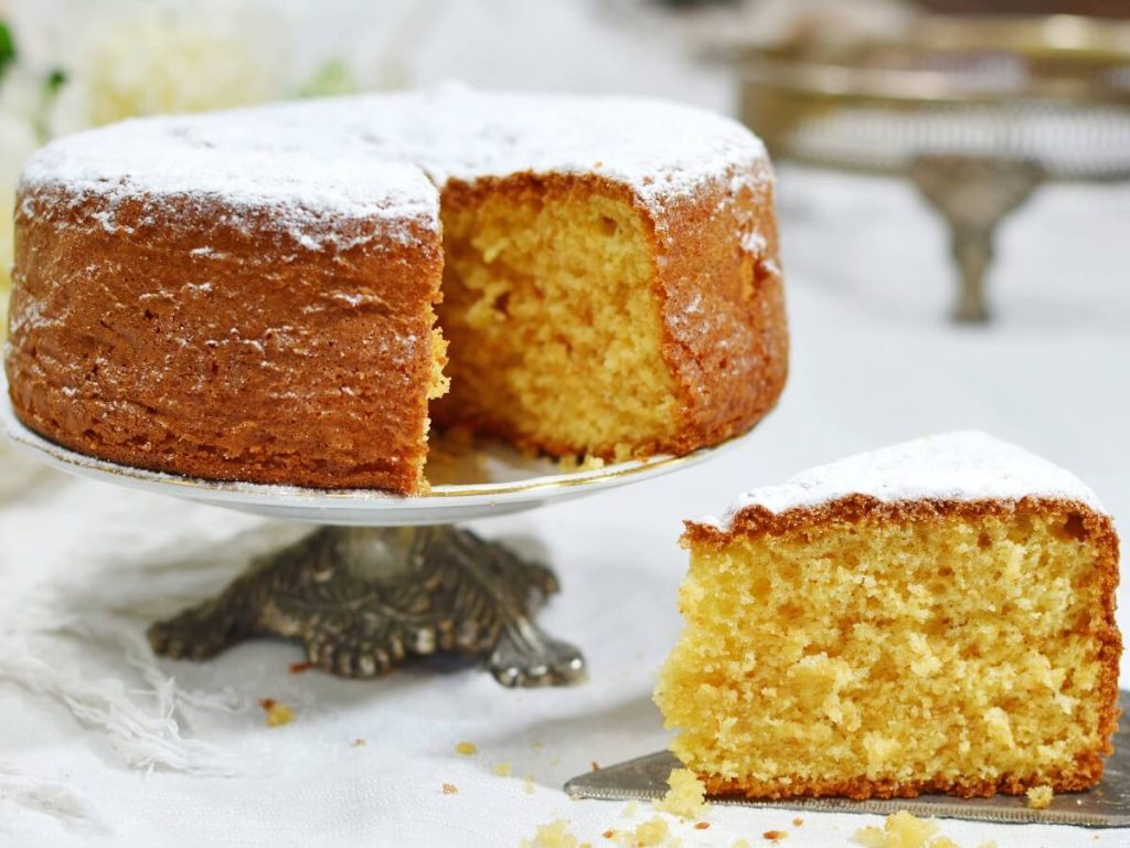 Torta soffice su alzatina con fetta in primo piano