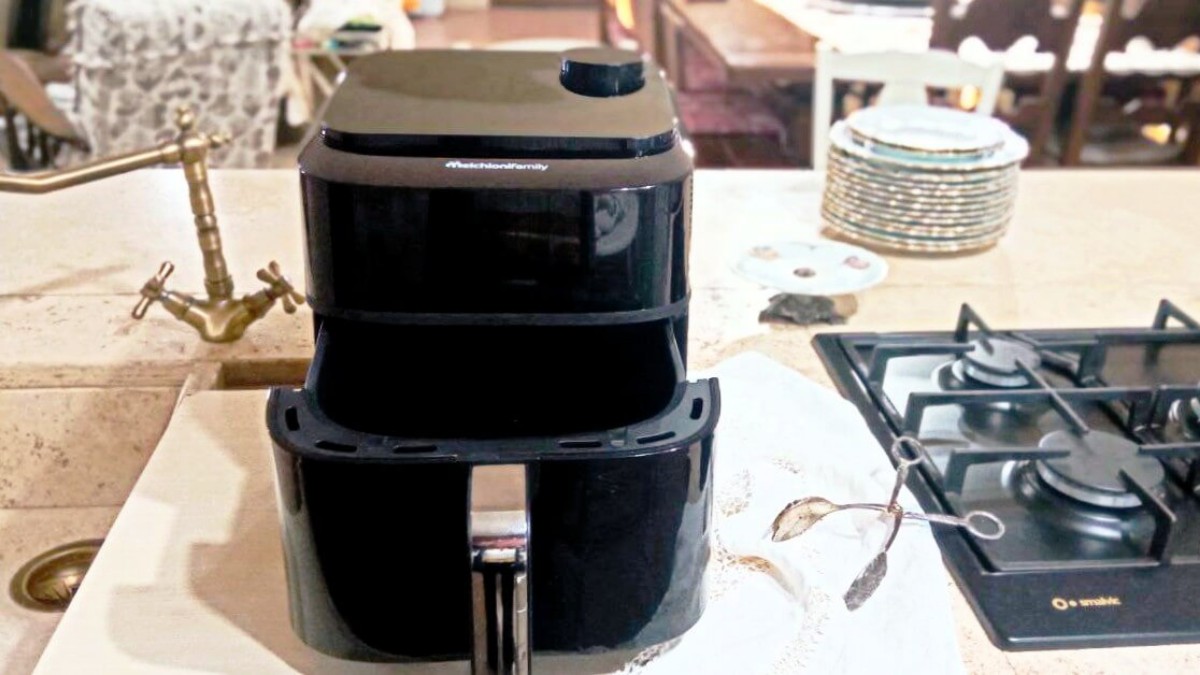 Friggitrice ad aria Melchioni Chiara su piano cucina in ambiente rustico, con cassetto aperto e accessori da cucina