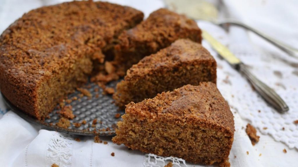 Torta alle Nocciole soffice senza burro – RicetteSOS. Torta rustica tagliata a spicchi su tovaglia bianca con posate vintage