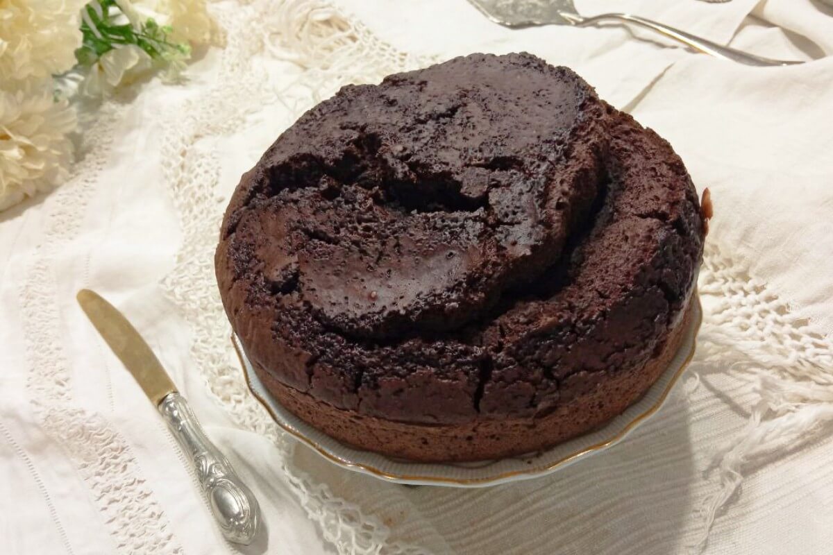 title="Torta al cacao soffice cotta nella friggitrice Melchioni Chiara, senza uova né latticini" Friggitrice ad aria con doppia resistenza Melchioni Chiara, torta al cacao soffice senza uova né latticini su tovaglietta con pizzo