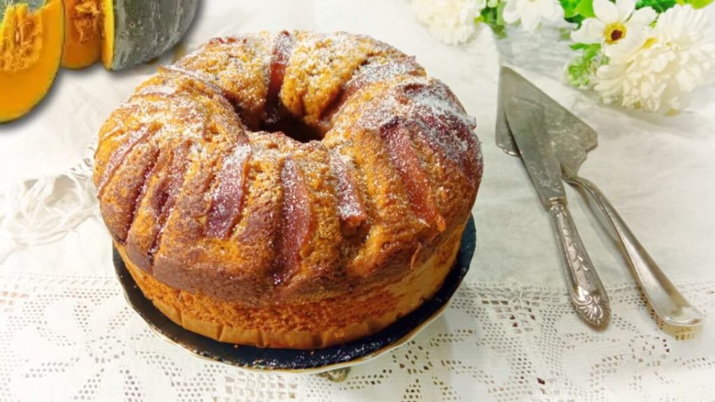 torta alla zucca light soffice Ricette SOS servita su piatto decorato con tovaglia bianca e fiori